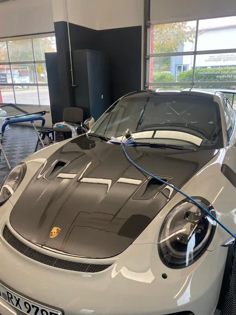 Steinschlagreparatur bei Porsche in Landsberg am Lech – Autoglas Stangl im Einsatz mit Spezialgerät zur punktgenauen Instandsetzung der Windschutzscheibe, Saugnapf-Tool exakt auf Steinschlagposition fixiert