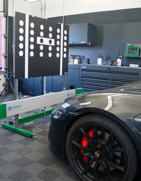 autoglas-stangl-scheibentausch-kalibrierung-landsberg-am-lech Kalibrierungstafel vor einem Porsche in der Werkstatt von Autoglas Stangl in Landsberg am Lech – Kalibrierung von Fahrerassistenzsystemen und Sensorik nach Scheibentausch